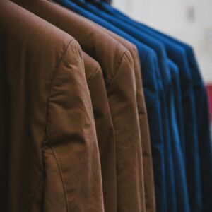 Showcase of neatly arranged brown and blue jackets on hangers, emphasizing fashion and style.
